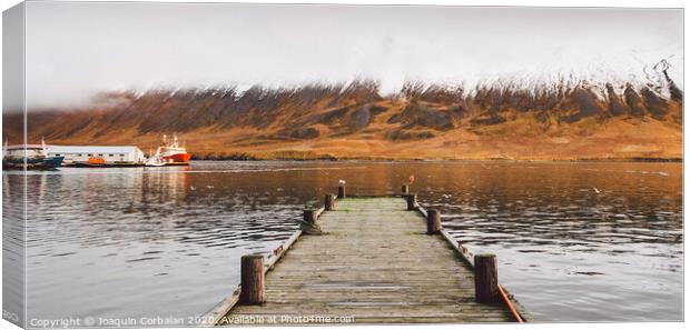 Small wooden pier centered on a lake, facing a snowy mountain. Canvas Print by Joaquin Corbalan