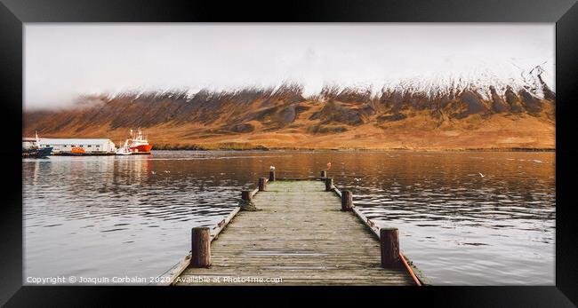 Small wooden pier centered on a lake, facing a snowy mountain. Framed Print by Joaquin Corbalan