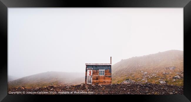 Small wooden hut on top of a mountain surrounded by fog in winter to seek solitude. Framed Print by Joaquin Corbalan