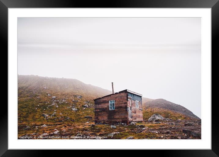 Small wooden hut on top of a mountain surrounded by fog in winter to seek solitude. Framed Mounted Print by Joaquin Corbalan