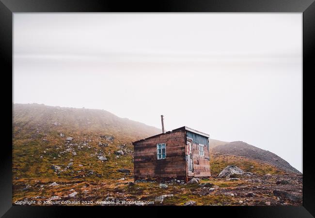 Small wooden hut on top of a mountain surrounded by fog in winter to seek solitude. Framed Print by Joaquin Corbalan