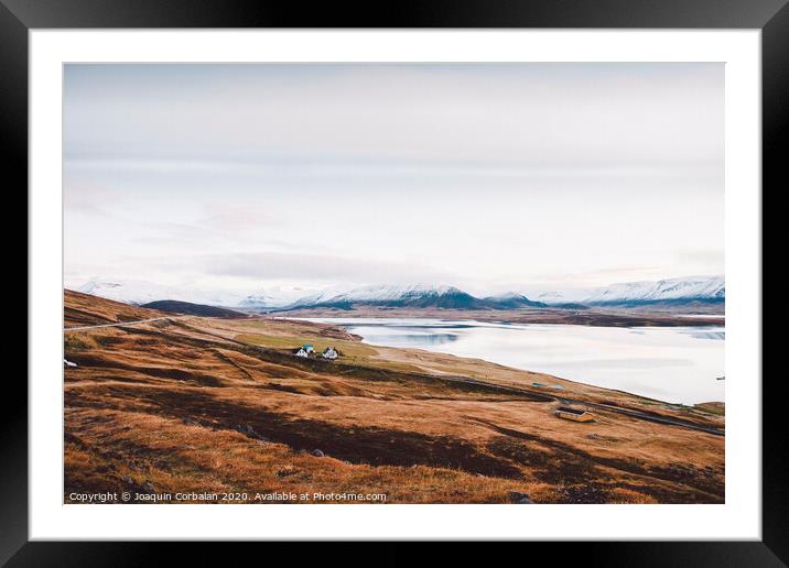 Village with farms in a rural area of the mountains of Iceland, with snowy mountains in the background. Framed Mounted Print by Joaquin Corbalan