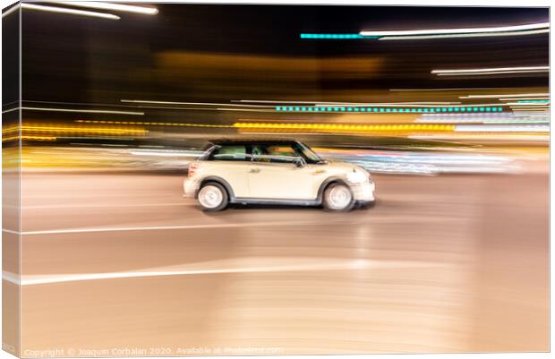 Car rolling at full speed through the city at night, image of panning, with defocused background lights. Canvas Print by Joaquin Corbalan