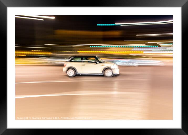 Car rolling at full speed through the city at night, image of panning, with defocused background lights. Framed Mounted Print by Joaquin Corbalan