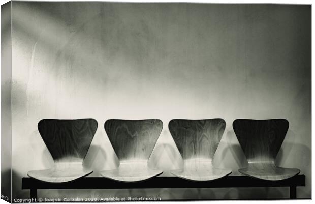 Waiting room with empty wooden chairs, concept of waiting and passage of time, black and white image, free space for text. Canvas Print by Joaquin Corbalan