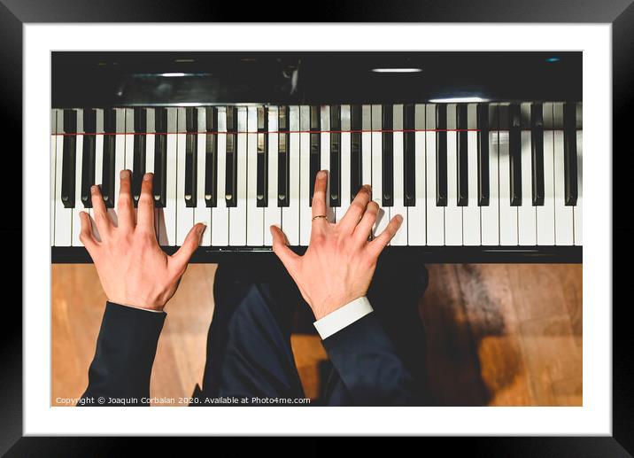 Pianist performing a piece on a grand piano with white and black keys., Seen from above... Framed Mounted Print by Joaquin Corbalan