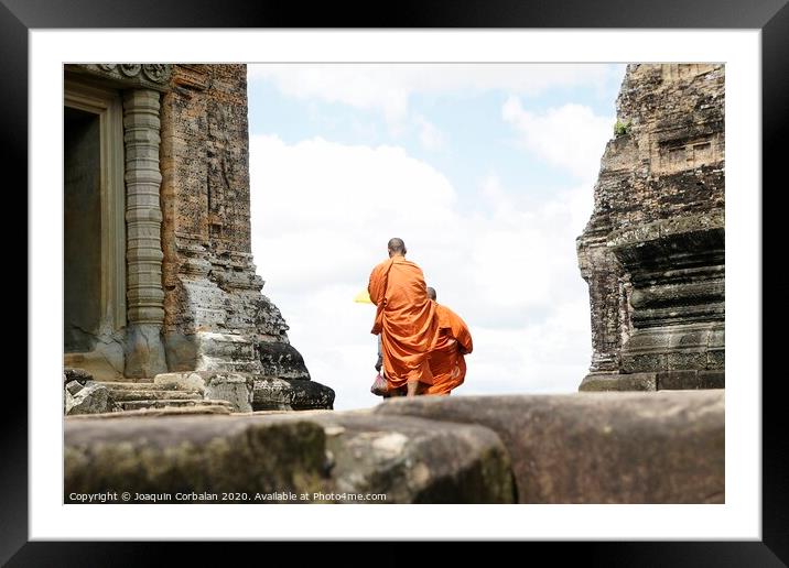 Tibetan monks in orange robes visiting remote Cambodian temples to meditate. Framed Mounted Print by Joaquin Corbalan