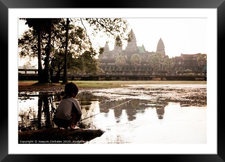 Girl fishing in the lake of Angkor Wat, ancient Cambodian city hidden in the forest very visited by tourists Framed Mounted Print by Joaquin Corbalan