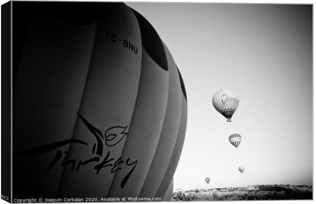 Goreme, Turkey - April 4, 2012: Hot air balloons for tourists flying over rock formations at sunrise in the valley of Cappadocia. Canvas Print by Joaquin Corbalan