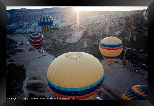 Hot air balloons for tourists flying over rock formations at sunrise in the valley of Cappadocia. Framed Print by Joaquin Corbalan