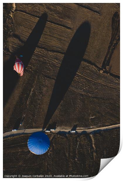 Hot air balloons for tourists flying over rock formations at sunrise in the valley of Cappadocia. Print by Joaquin Corbalan
