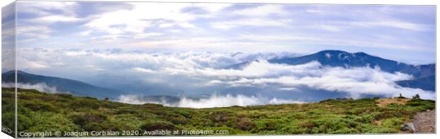 Panoramic image of the views of the Sierra de Guadarrama with its clouds from the top of a mountain peak. Canvas Print by Joaquin Corbalan
