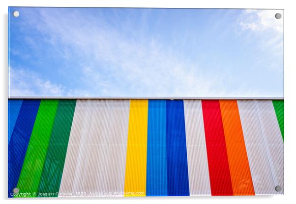 Facade with colored lines, against the blue sky in the background. Acrylic by Joaquin Corbalan