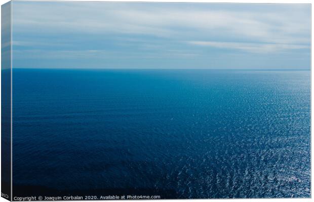 Calm blue sea without waves seen from a cliff with room for text Canvas Print by Joaquin Corbalan