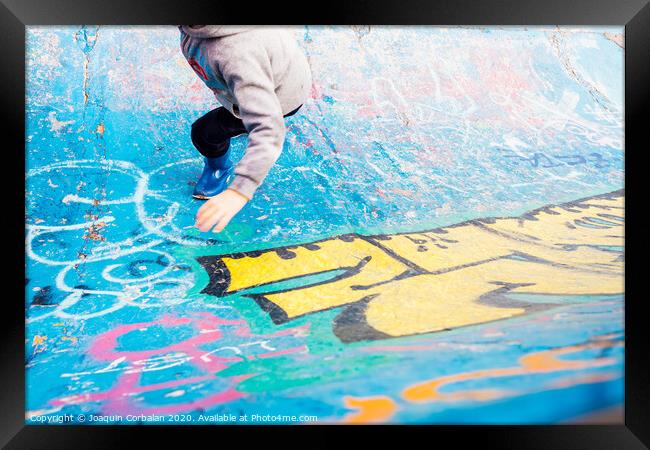 Boy running inside an urban skatepark with sweatshirt having fun, blue tones. Framed Print by Joaquin Corbalan