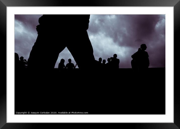 Backlight of a cloudy day with a silhouettes of a group of unrecognizable people. Framed Mounted Print by Joaquin Corbalan