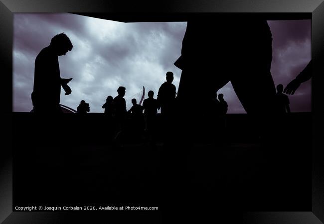 Silhouette of a group of unrecognizable people using their smartphones, socially isolated. Framed Print by Joaquin Corbalan