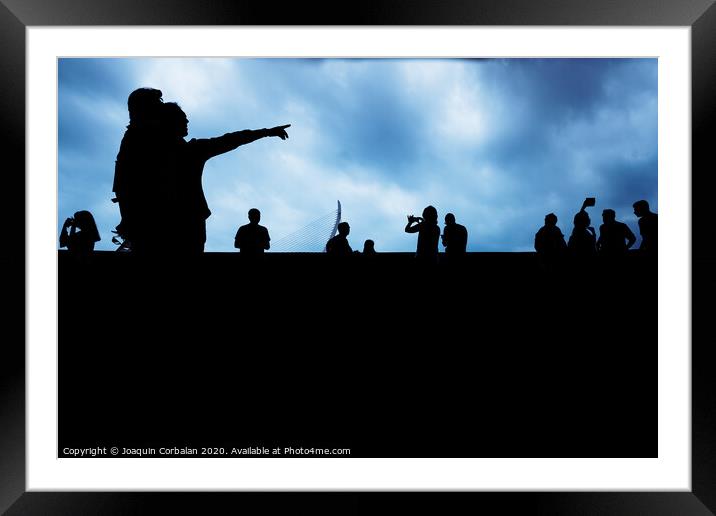 Silhouette of unrecognizable people pointing with a dark background. Framed Mounted Print by Joaquin Corbalan
