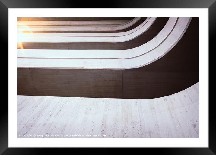 Warm tones background of the interior of a minimalist construction of rough textured walls and lines, illuminated with a sunbeam at sunset. Framed Mounted Print by Joaquin Corbalan