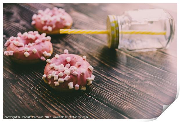 Pair of buns frosted with pink sugar and unhealthy marshsmallows next to a glass jar. Print by Joaquin Corbalan