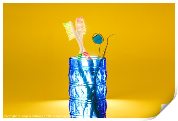 New plastic toothbrushes inside a glass, isolated on bright orange background, with copy space. Print by Joaquin Corbalan