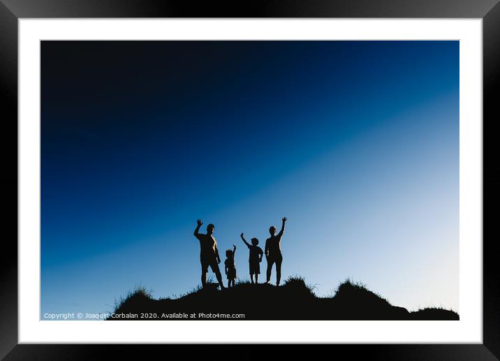 Silhouette of a happy family on top of a hill waving at sunset. Framed Mounted Print by Joaquin Corbalan