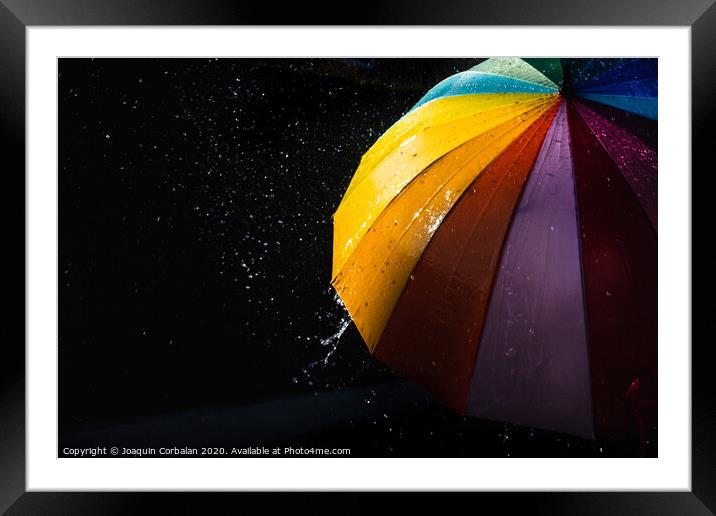 Rain on a warm-toned umbrella lit by the sun, isolated on black background with copy space. Framed Mounted Print by Joaquin Corbalan