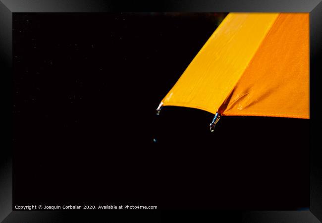 Multicolored umbrella under raindrops isolated on black as background. Framed Print by Joaquin Corbalan
