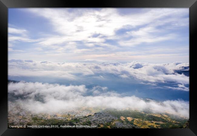 Scene of a winter cloudy sky from the top of a mountain peak. Framed Print by Joaquin Corbalan