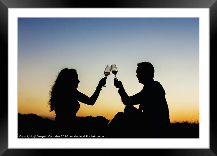 Enamored couple embraced at sunset in a backlit photo Framed Mounted Print by Joaquin Corbalan