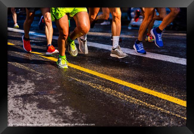 Muscled legs of a group of several runners training running on asphalt Framed Print by Joaquin Corbalan