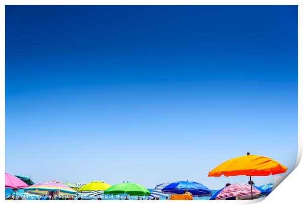Colorful beach umbrella stuck in the sand surrounded by a group of bathers in summer, near the Mediterranean sea. Print by Joaquin Corbalan
