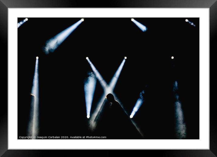 Silhouette of some workers illuminated by the spotlights of a stage while checking the limit and the effects of smoke. Framed Mounted Print by Joaquin Corbalan