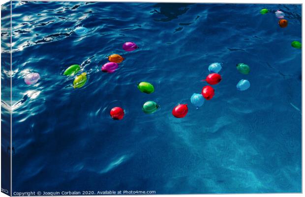 Colorful plastic water balloons floating in a pool to play on vacation to cool off. Canvas Print by Joaquin Corbalan