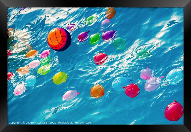Group of many colorful plastic water balloons floating in the water of a pool to entertain their children on summer vacations. Framed Print by Joaquin Corbalan