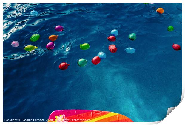 Group of many colorful plastic water balloons floating in the water of a pool to entertain their children on summer vacations. Print by Joaquin Corbalan
