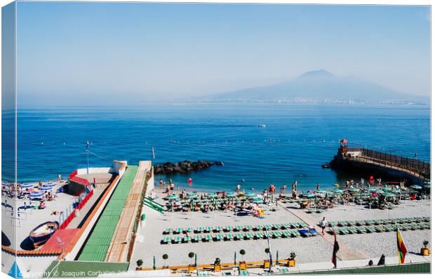  A beach with sunbathers in Sorrento, with background of unfocused view of Vesuvius volcano. Canvas Print by Joaquin Corbalan