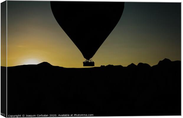 Silhouette of travelers and tourists flying over mountains at sunset in an aerostatic balloon. Canvas Print by Joaquin Corbalan