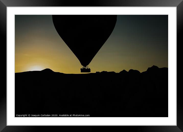 Silhouette of travelers and tourists flying over mountains at sunset in an aerostatic balloon. Framed Mounted Print by Joaquin Corbalan