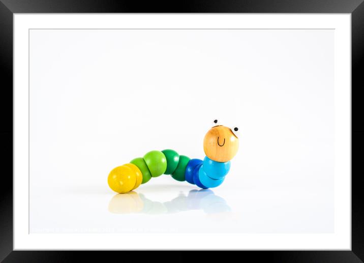 Toy caterpillar with smile, to illustrate concepts of infant intestinal health. Framed Mounted Print by Joaquin Corbalan
