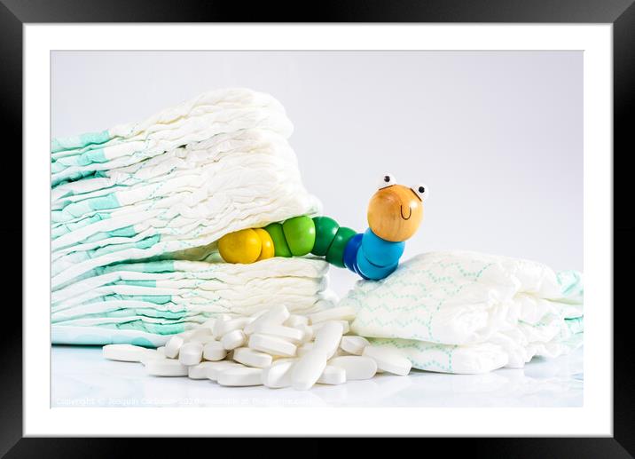 Enterobiasis is a infections of worms, Enterobius vermicularis or pinworms, which affects children and babies. A toy worm with some diapers and pills. Framed Mounted Print by Joaquin Corbalan