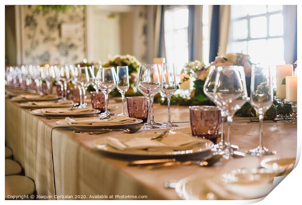 Elongated table with all the cutlery elegantly arranged and beautiful centerpieces ideal for decorating a wedding. Print by Joaquin Corbalan