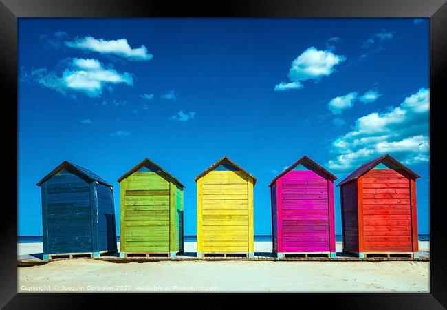Colorful wooden changing huts on a beach, with nice background of clear blue sky on the coast. Framed Print by Joaquin Corbalan