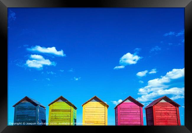 Colorful wooden changing huts on a beach, with nice background of clear blue sky on the coast. Framed Print by Joaquin Corbalan