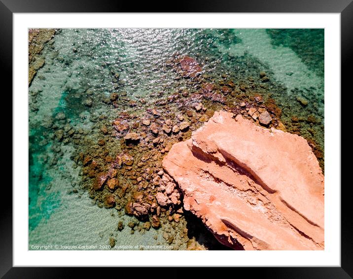 Aerial view of a natural rock jetty on the Mediterranean coast with transparent turquoise waters. Framed Mounted Print by Joaquin Corbalan