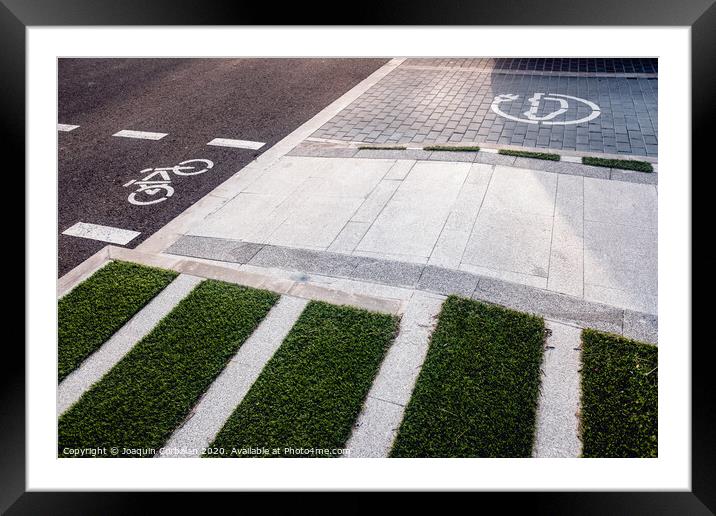 New bike lanes next to recharging stations for electric vehicles on paved asphalt. Framed Mounted Print by Joaquin Corbalan