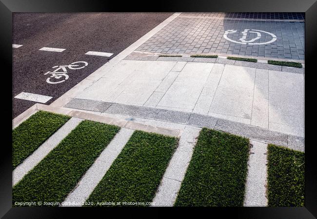 New bike lanes next to recharging stations for electric vehicles on paved asphalt. Framed Print by Joaquin Corbalan