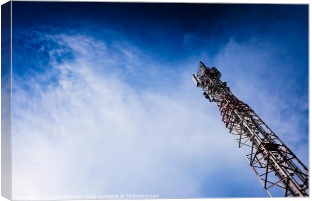 A tall modern communications tower provides telecommunications service to a city, negative space on blue background. Canvas Print by Joaquin Corbalan