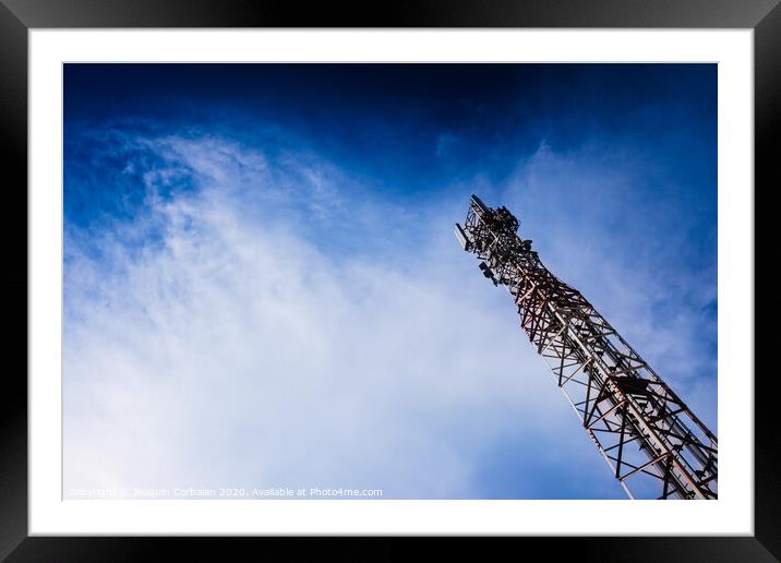A tall modern communications tower provides telecommunications service to a city, negative space on blue background. Framed Mounted Print by Joaquin Corbalan