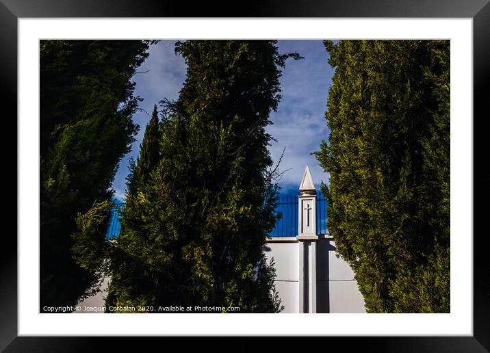 High white concrete walls with metal grating of a cemenery, seen through the cypress trees. Framed Mounted Print by Joaquin Corbalan